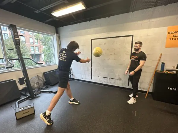 physical therapist throwing a ball with client